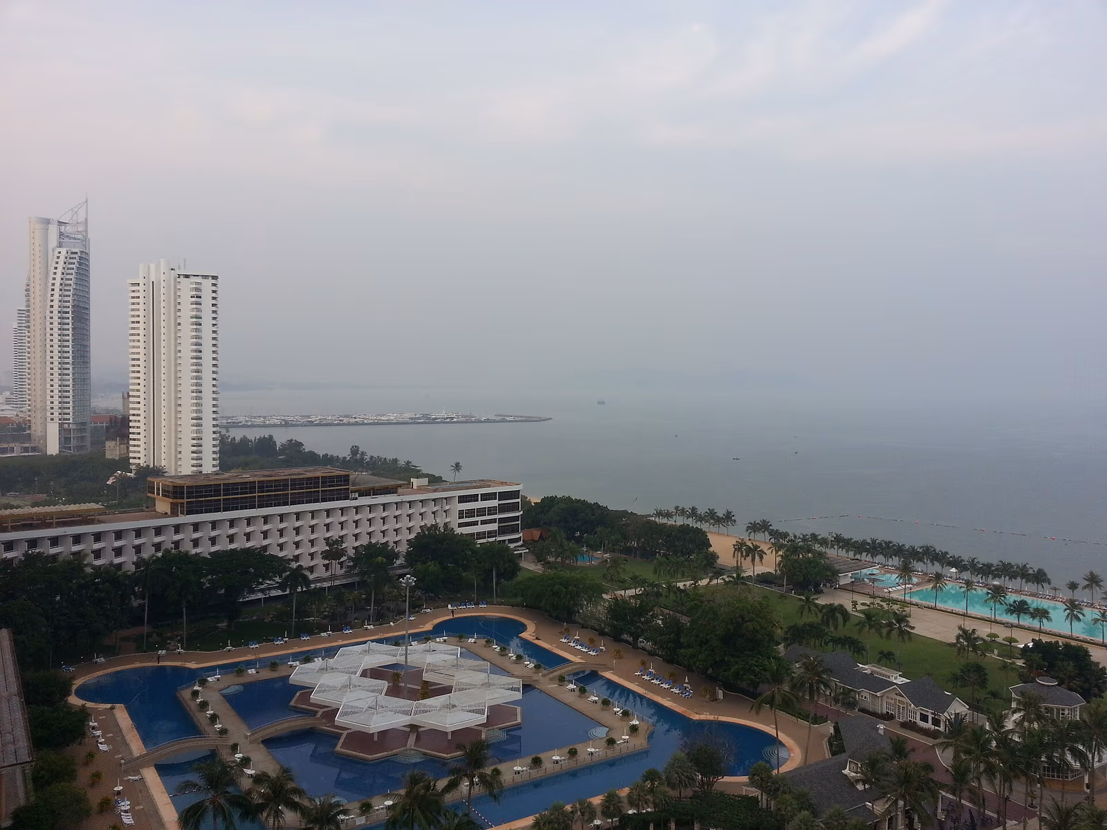 Aerial view of Na Jomtien beach, coconut trees and low-rise beachfront condos at Ban Amphur