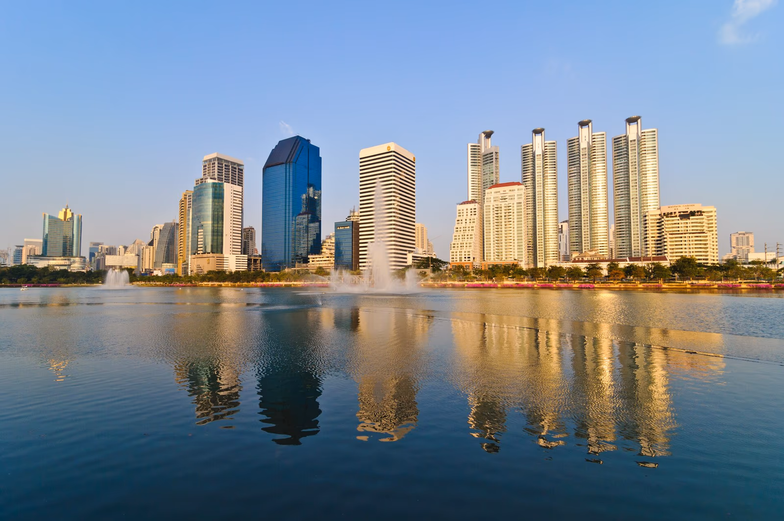 Ashton Asoke condominium tower in Bangkok with BTS Asoke station in the foreground, representing Ananda Development's focus on mass-transit-connected urban residences